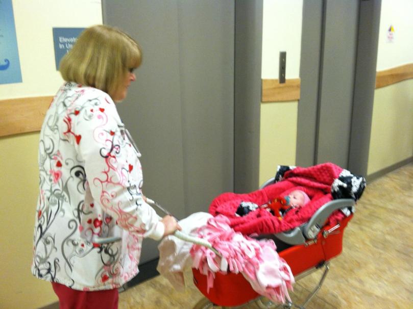 Nurse Judy wheeling Evie down to the car